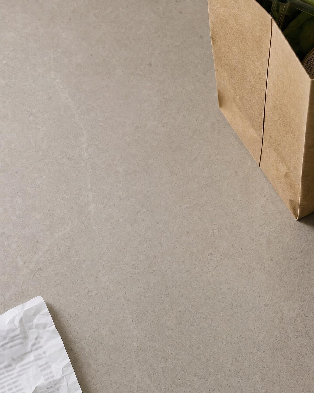 A kitchen counter with a paper grocery bag, a crumpled receipt and a wallet